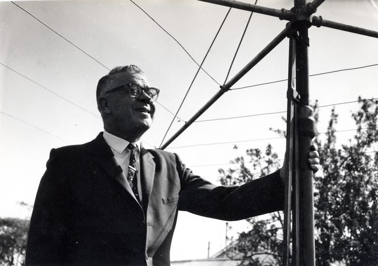 Lance Hill standing beside one of the original Hills Hoist rotary clotheslines